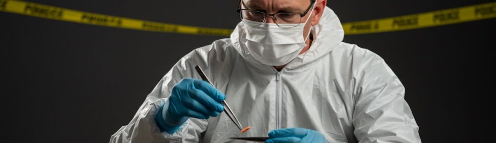 Forensic science technician analyzing evidence samples at crime scene with police tape